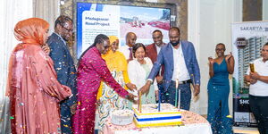 Trade Cabinet Secretary Rebecca Miano and officials of Gabeire A Group (GAG) cutting a cake to commemorate the beginning of the construction project.