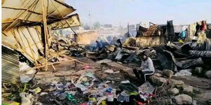 A resident of  Soweto in Embakasi is pictured beside the  houses burned down in Soweto on February 7