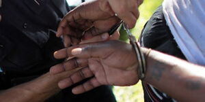 Police placing a suspect in handcuffs during an arrest.