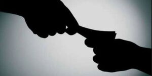 A silhouette of a person offering a bribe