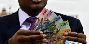 Former CBK Governor Patrick Njoroge holding bank notes.