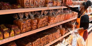 A woman shopping for bread in a supermarket.