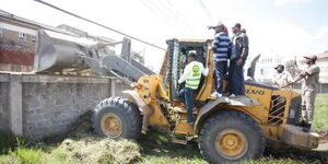 Nairobi officials supervise the demolition of a wall on a road reserve along Access Road in South C estate on July 16, 2020. 