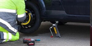 An image of a mechanic replacing a donut tyre.