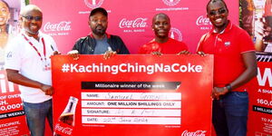 Theuri Chege, Coca-Cola Kenya Franchise Director (right), and Seth Adu-Baah, CEO of Coastal Bottlers Kenya (left), handing over a one million cheque to Samuel Gitonga, (2nd left), who is the 4th winner of the Kaching Ching Na Coke millionaire weekly prize. Also present was content creator Crazy Kennar.
