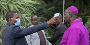 A health officer screens a clergyman for a rise in temperature at StateHouse, Nairobi on Saturday, March 21, 2020.