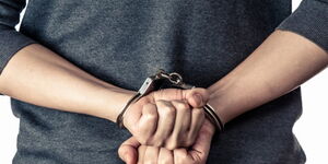 Chinese national in handcuffs