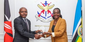 Defence Cabinet Secretary  Soipan Tuya (left) receiving an award from  Principal Secretary Patrick Mariru on  Wednesday, December 10