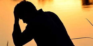 A silhouette image of a depressed man