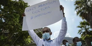 A file image of a Doctor holding a placard during a previous Doctor's strike in Kenya