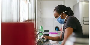 A domestic worker doing dishes in the kitchen of a household in Kenya.