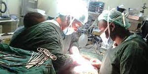 Dr Swabra Swaleh operating on a pregnant woman while having her child strapped on her back