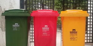 A photo of 3 waste disposal dustbins on display.