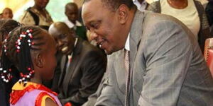 President Uhuru Kenyatta congratulates six-year-old Emily Wanjiru during the Kenya National Drama Festivals finalist concert at State Lodge, Sagana in 2014.