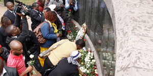 People lay flowers at the U.S. Embassy bombing memorial site in Nairobi, Kenya, Aug. 7, 2013, to mark the 15-year anniversary of the 1998 embassy bombing.