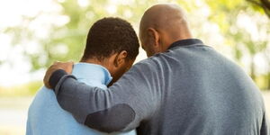 A stock image of a father and on embracing each other