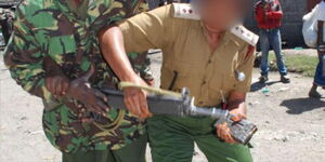 A female officer tries to disarm a G3 riffle from a colleague at Bondeni estate in Nakuru town. 