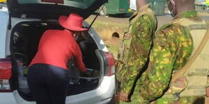 Woman sharing food with police officers at Thika-Murang'a roadblock