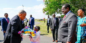 Haiti Prime Minister Garry Conille receiving flowers from a young girl at the Jomo Kenyatta International Airport (JKIA) on October 10, 2024