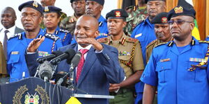 Interior CS Kithure Kindiki (in suit) addresses the press in the company of IG Japhet Koome (right)