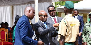 Interior PS Raymond Omollo awards a security force number to a guard in Uasin Gishu.