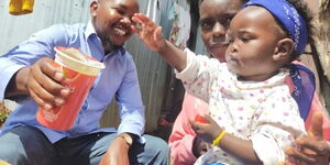 Joseph Murimi (left) with Baby Elsie who sought medical assistance over a skin disease 