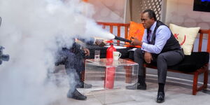 Citizen TV anchor Jeff Koinange using an extinguisher during an interview on JKL in 2019.
