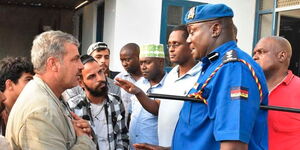 Mvita Sub-County Police Commander Maxwell Agoro speaks to some of the 40 Jordanians who were arrested in Mombasa's Marikiti area