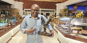 Journalist Alex Chamwada poses with the the Pioneer,Trailblazer award he received from Kenya Editors Guild.
