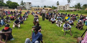 A police officer inspect youth awaiting to be listed under the Kazi Mtaani program phase 1.