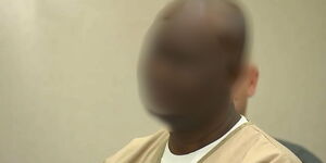 A photo of a Kenyan man in USA who was arrested for allegedly hiring hitman to assassinate his wife.