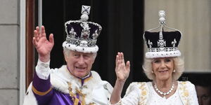 King Charles III and Queen Camila wave at a crowd