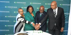 Marion Ndungu (left) and Mary Wambugu (2nd left) join Edward Njoroge, Branch Manager of Kingdom Bank's Gikomba Branch (2nd right) and Alex Kasiki, Head of Business Development at Kingdom Bank, in cutting a cake during the official opening of the bank's 20th branch in Gikomba.