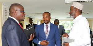 PS Nixon Korir (centre) chatting with LSK President Eric Theuri (left) and the Chairman of the Association of Licensed Land Surveyors of Kenya Abdulkadir Khalif (right) at the Geospatial Data Center in Ruaraka Nairobi after a stakeholders meeting to discuss the Ardhisasa platform on April 12, 2023.