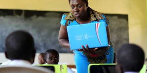 A teacher at Butere Primary School in Kakamega County introduces her pupils to digital tablets on May 3, 2016