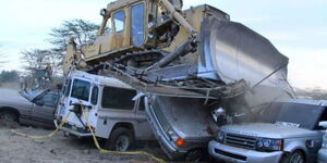 An excavator crashes contraband vehicles in 2018.