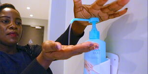 A Kenyan using handsanitizer