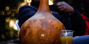 A group of people enjoying muratina served in a traditional bowl.