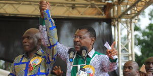 National Assembly Speaker Moses Wetangula (right) raises Lugari MP Nabii Nabwera's hand during a funds drive in aid of Lwandeti DEB secondary school in Lugari constituency on June 10, 2023.  