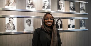Nadia Mohamed, Mayor St Louis Park poses for a photo in front of a gallery wall of all mayors of the city
