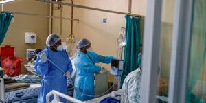 Nurses attend to patients in a hospital ward. 