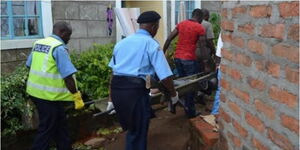 A file image of officers ferrying a body from a residential area.