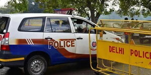 Indian police car parked on a barricaded road during an operation 