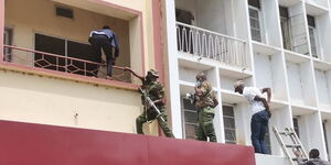 Police try to access a bank that was robbed in Kisumu on Tuesday, November 23.