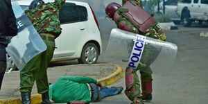Photo of Kenyan police officers roughing up a protestor.