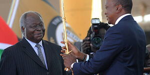 President Uhuru Kenyatta receives a sword as a symbol of authority from former president Mwai Kibaki during his inauguration at the Moi International Sports Center Kasarani in Nairobi on April 9, 2013