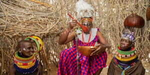 Photo of President Ruto trying out a traditional meal at the Turkana Cultural Festivals in Lodwar October 12, 2023