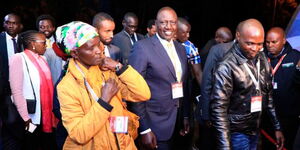 President William Ruto (centre) next to a mama mboga and boda rider at the CUEA during the presidential debate in July 26, 2022