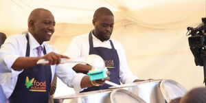 President William Ruto (left) and Nairobi Governor Johnson Sakaja (right) during a feeding drive at a school on June 20, 2023
