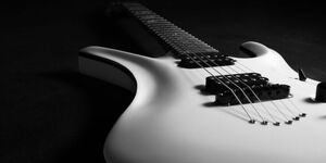 A picture of a guitar on the ground. 